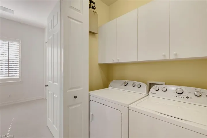 Laundry room with washer and clothes dryer and cabinets