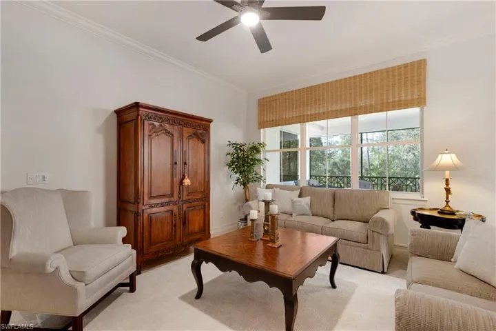 Living room with ceiling fan and ornamental molding