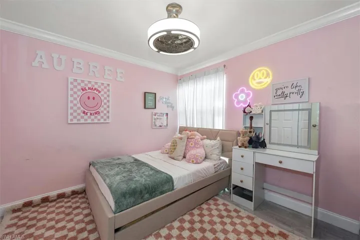 Bedroom featuring ornamental molding and wood finished floors
