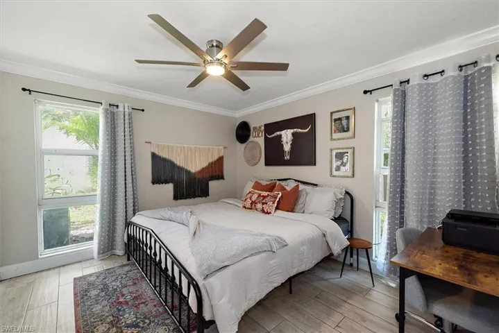 Bedroom featuring ornamental molding, light wood finished floors, and ceiling fan