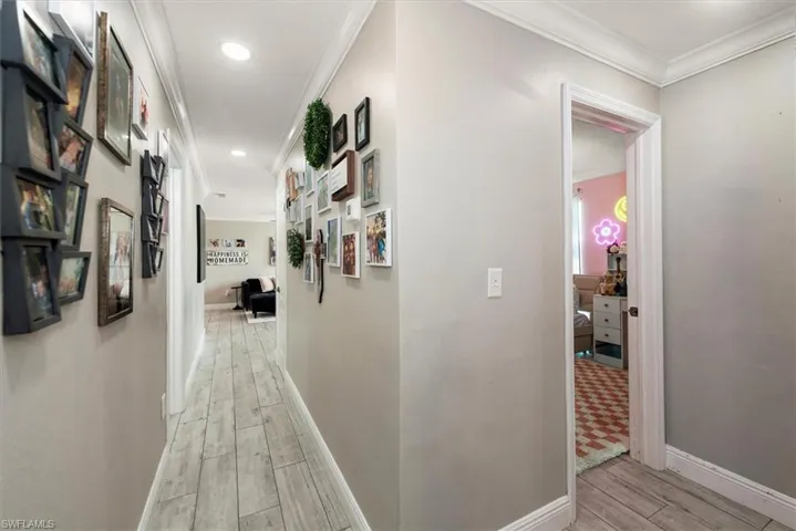 Hallway with ornamental molding, wood finish floors, and recessed lighting