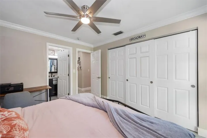 Bedroom with crown molding, ceiling fan, and a closet