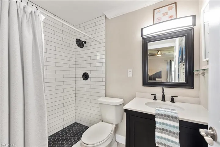 Bathroom with vanity, a shower stall, and ornamental molding
