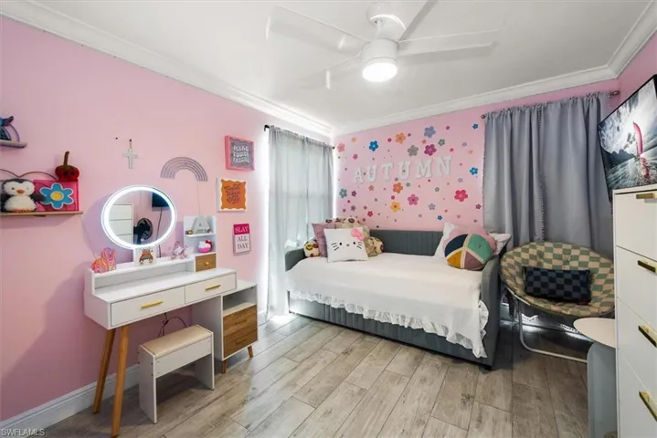 Bedroom with crown molding, light wood finished floors, and ceiling fan