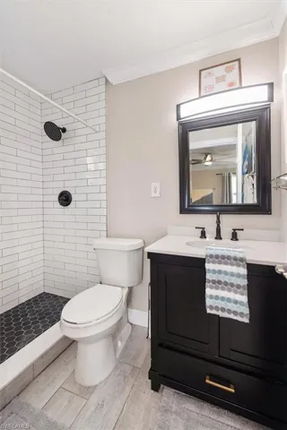 Full bathroom with vanity, a stall shower, crown molding, and light wood-type flooring