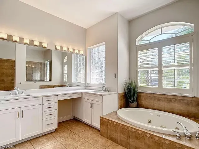 Bathroom featuring oversized vanity, double sink, tile floors, and plenty of natural light