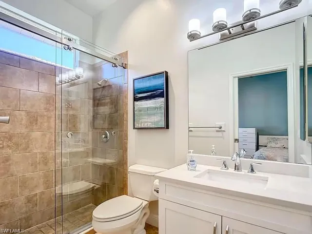 Bathroom with walk in shower, toilet, and vanity