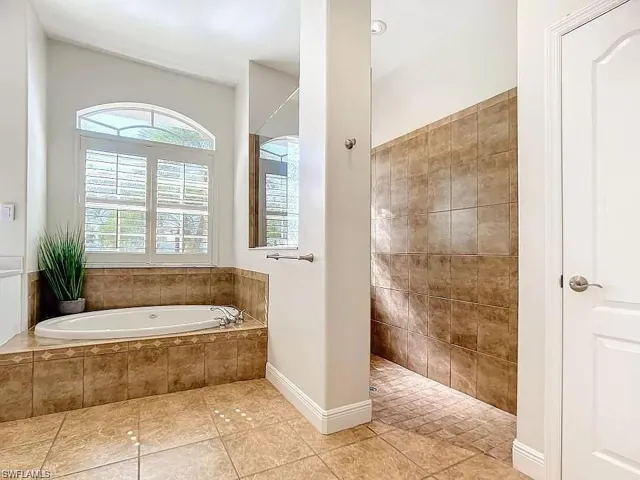 Bathroom with tile flooring and shower with separate bathtub