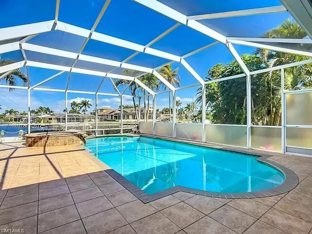 View of pool with a lanai and a patio