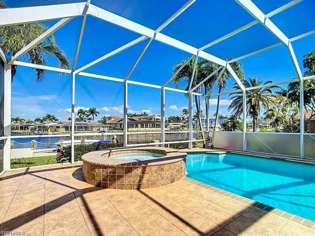 View of swimming pool featuring a patio, a lanai, and an in ground hot tub