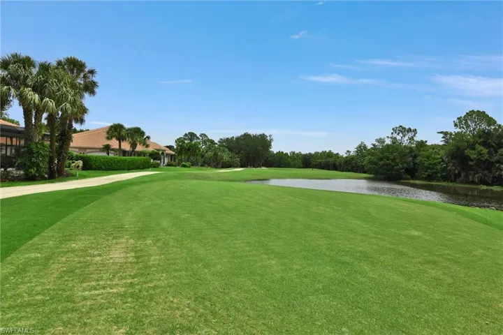 View of home's community with a water view and a lawn