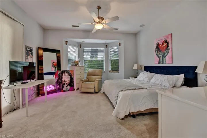 Carpeted bedroom featuring ceiling fan