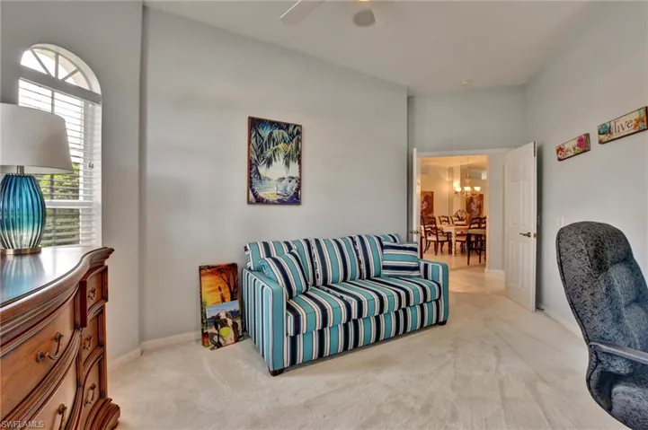 Carpeted living room featuring a notable chandelier