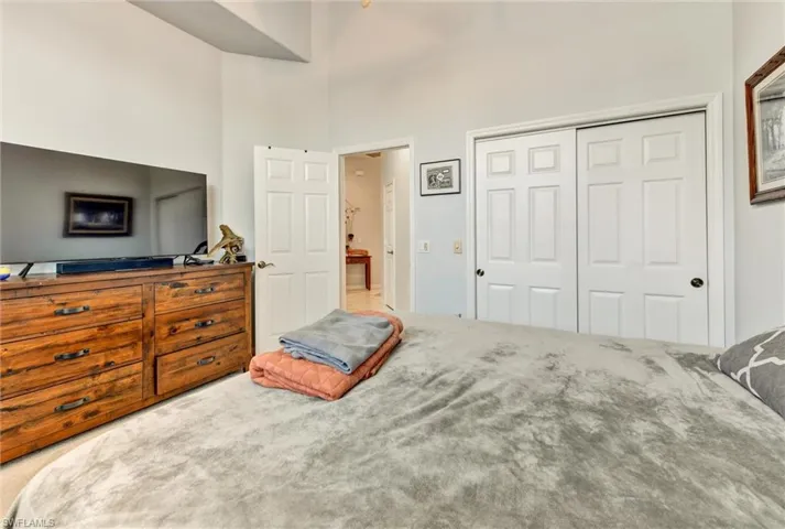 Bedroom featuring a towering ceiling, a closet, and carpet floors