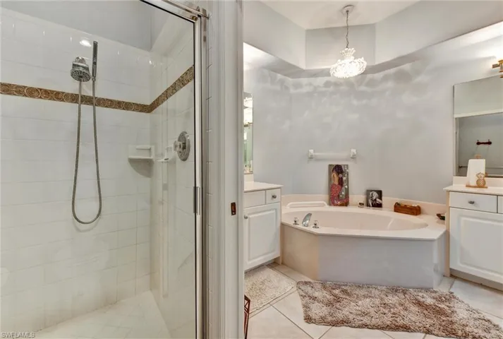 Bathroom featuring plus walk in shower, tile floors, and vanity