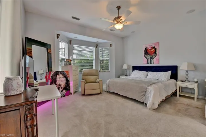 Carpeted bedroom featuring ceiling fan