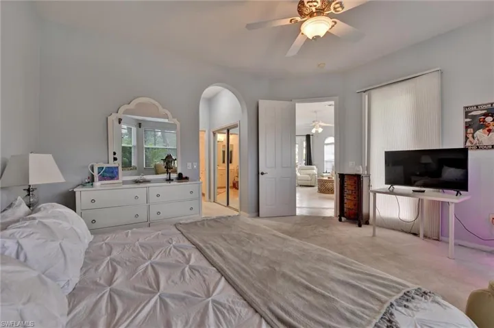 Bedroom with ceiling fan and light colored carpet