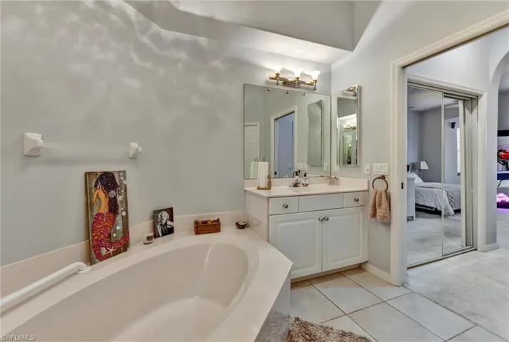 Bathroom featuring a tub, tile flooring, and large vanity