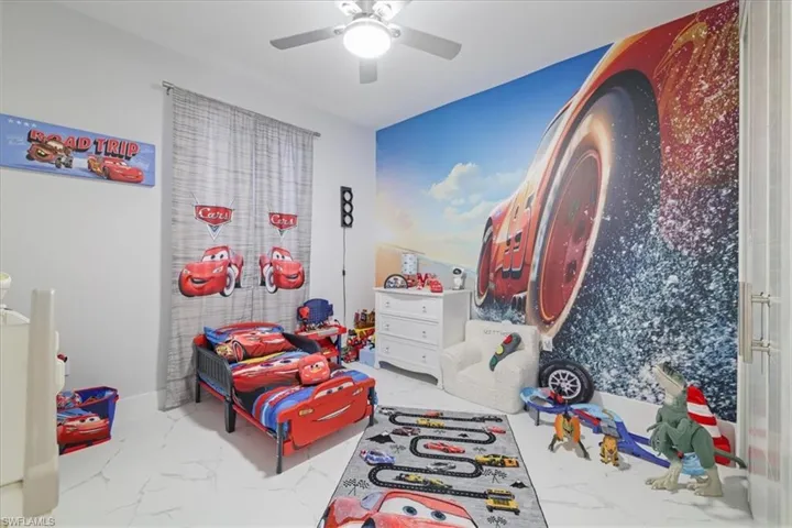 Rec room with light marble finish floors and ceiling fan