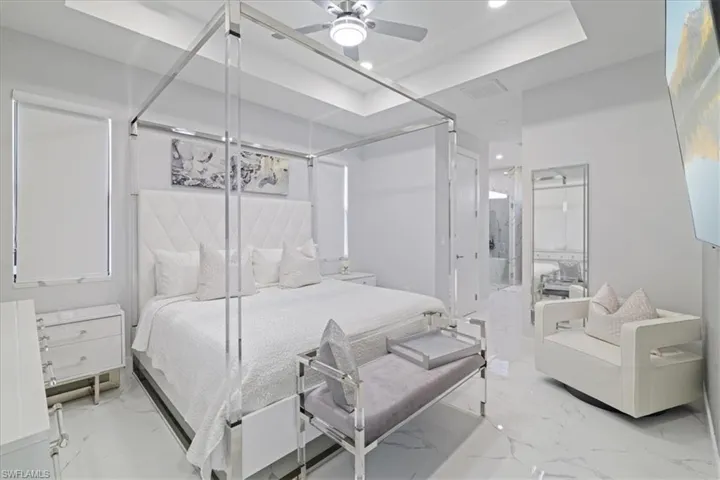 Bedroom featuring light marble finish floors, ceiling fan, and recessed lighting