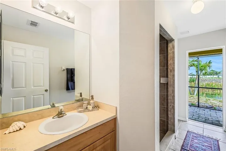 Bathroom vanity featuring a single basin, light-toned countertop, and wood-finish cabinetry