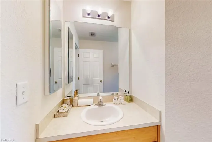 Bathroom vanity with an integrated sink, laminate countertop, and wood-finish cabinetry