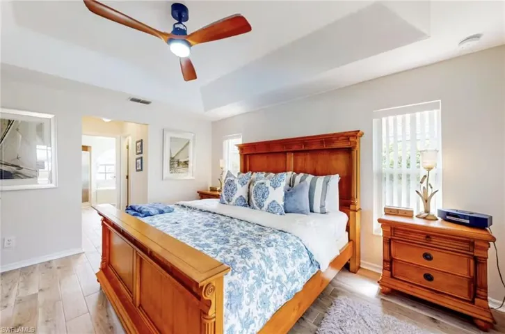 Recessed ceiling with a modern ceiling fan featuring wood-finish blades and integrated lighting