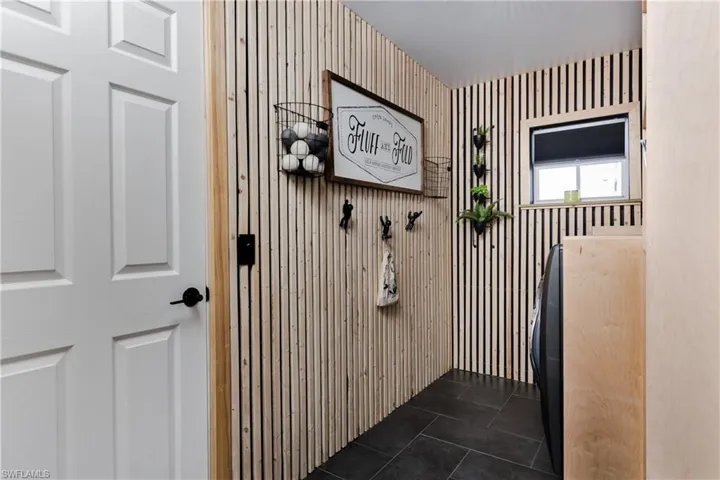 Laundry room with dark tile patterned flooring