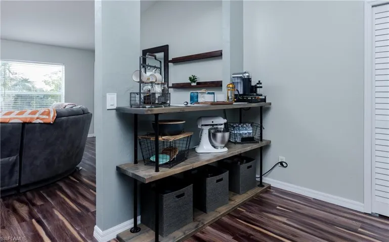Bar featuring dark wood finished floors and open shelves