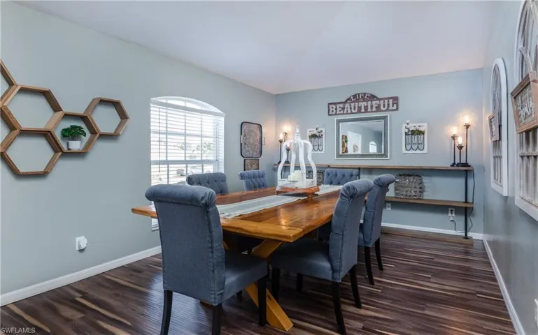 Dining area with dark wood-type flooring and vaulted ceiling