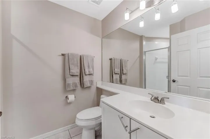 Guest Full bathroom featuring a shower stall, vanity, and light tile patterned floors