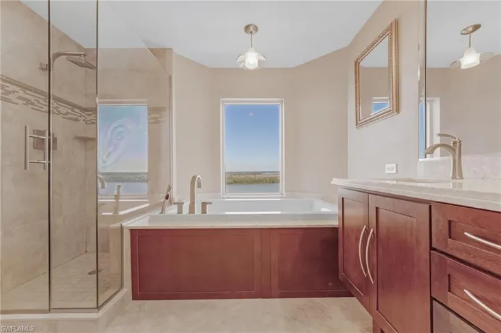 Full bathroom with 2 sink vanity, a separate bath, and a shower stall