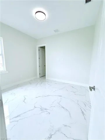 Empty room featuring baseboards and marble finish flooring