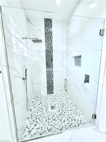 Full bathroom with a marble finish shower