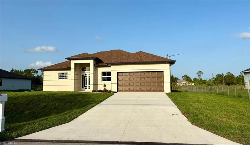 View of front of house with an attached garage, stucco siding, and driveway