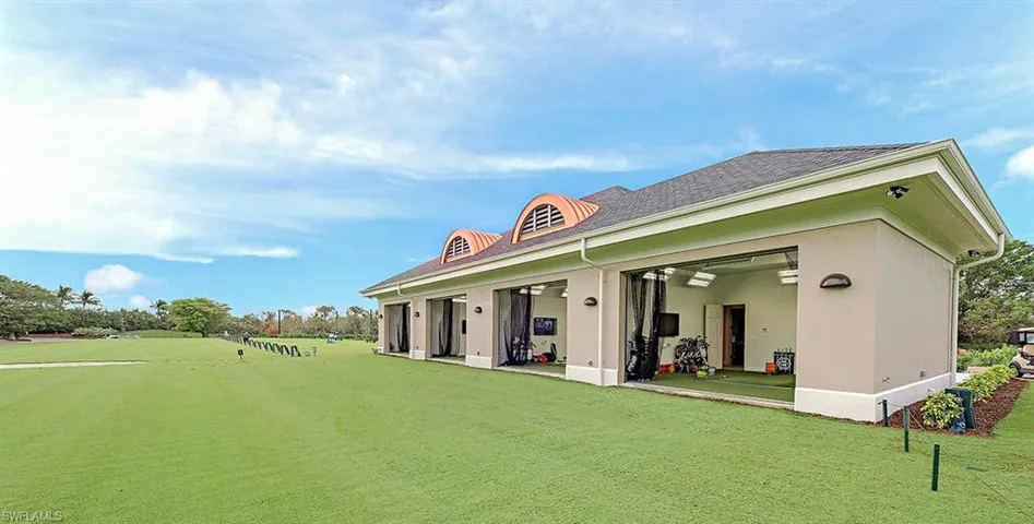 Rear view of property featuring a yard, stucco siding, and covered porch
