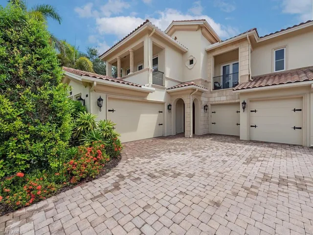 Mediterranean / spanish-style house with a balcony, stucco siding, decorative driveway, and a tile roof
