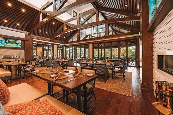 Dining space with high vaulted ceiling, hardwood / wood-style flooring, healthy amount of natural light, wood walls, and beamed ceiling