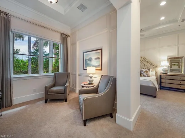 Sitting room featuring crown molding, light colored carpet, recessed lighting, and a decorative wall