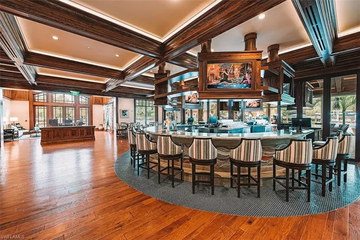 Bar with coffered ceiling, beam ceiling, dark wood-type flooring, ornamental molding, and recessed lighting