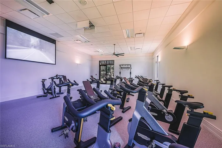 Exercise room with ceiling fan and a paneled ceiling