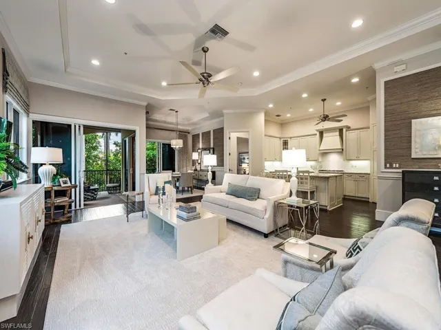 Living area with dark wood finished floors, crown molding, recessed lighting, a raised ceiling, and a ceiling fan
