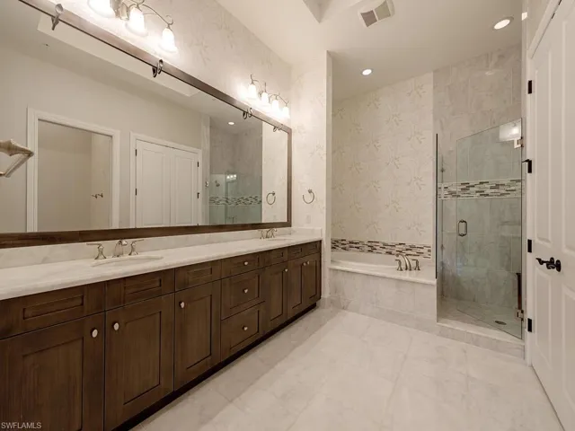 Bathroom featuring a shower stall, a garden tub, double vanity, recessed lighting, and wallpapered walls
