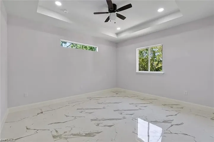 Spare room with baseboards, recessed lighting, and a raised ceiling