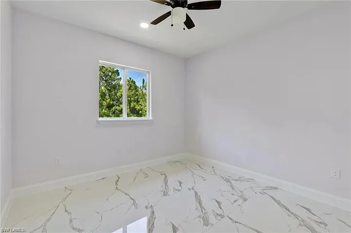 Spare room with recessed lighting, marble finish floor, baseboards, and a ceiling fan