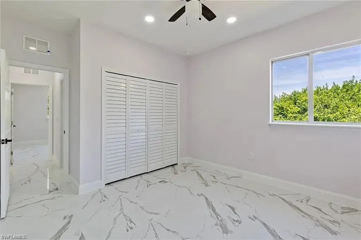 Unfurnished bedroom with recessed lighting, marble finish floor, visible vents, a closet, and baseboards