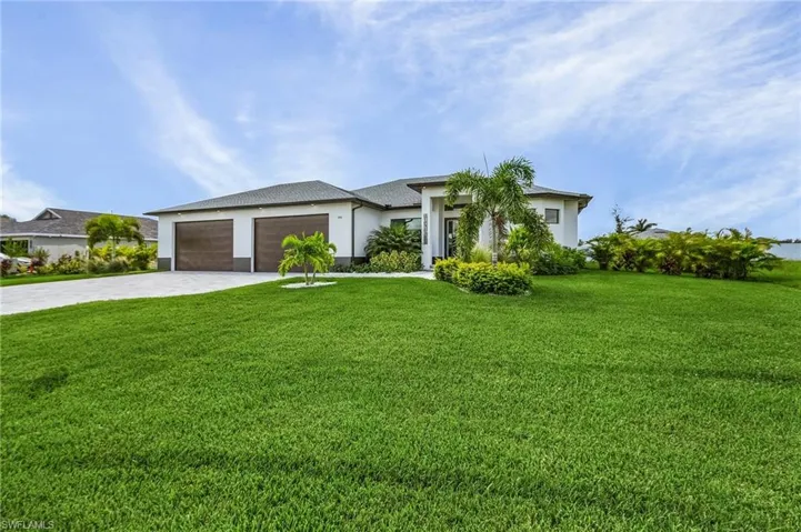 View of front of house with a front yard and a garage