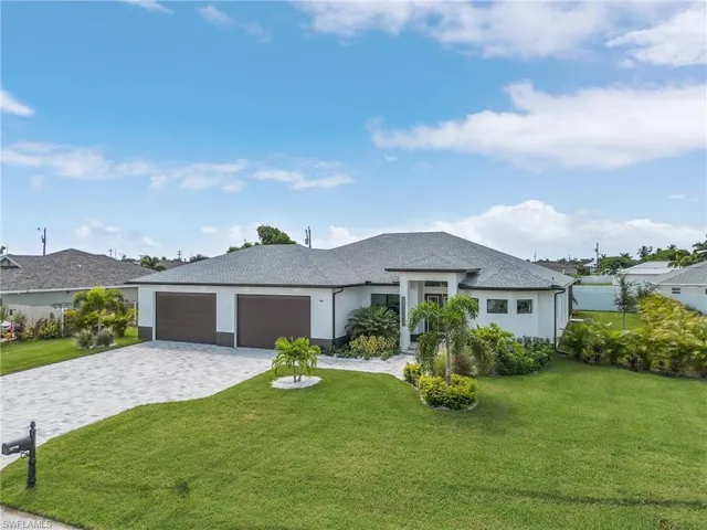 View of front of home with a garage and a front lawn