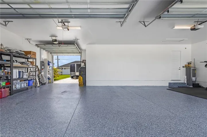 Garage featuring water heater and a garage door opener