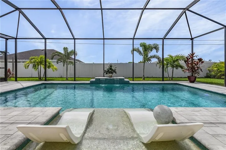 View of swimming pool featuring pool water feature, a patio, and a lanai